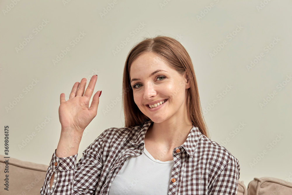 A beautiful smiling girl sitting on the couch looks at the camera. A beautiful smiling girl sitting on the couch looks at the camera.