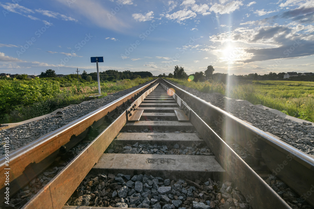 Fototapeta premium railroad tracks in the countryside at sunset
