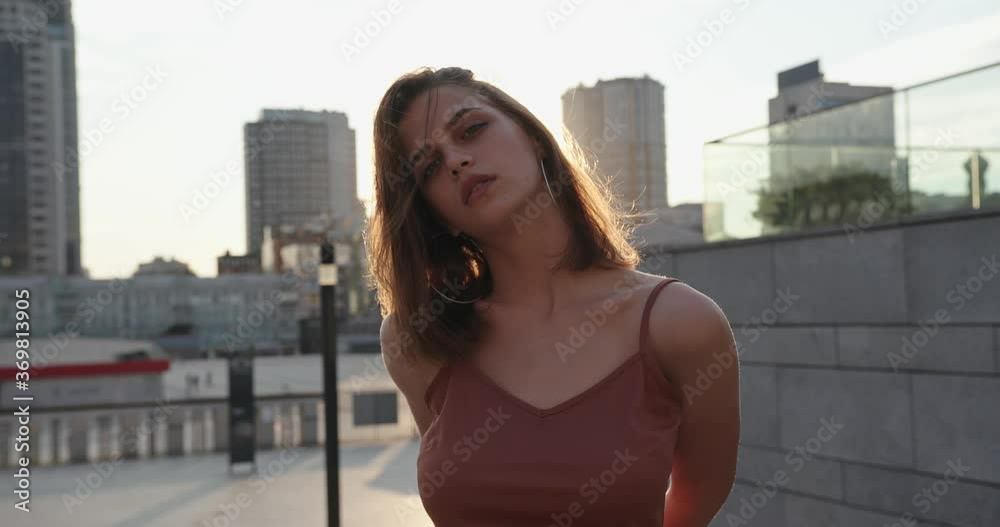 Beautiful brunette young woman model wearing brown dress and posing on the street. Beautiful brunette young woman model wearing brown dress and posing on the street.