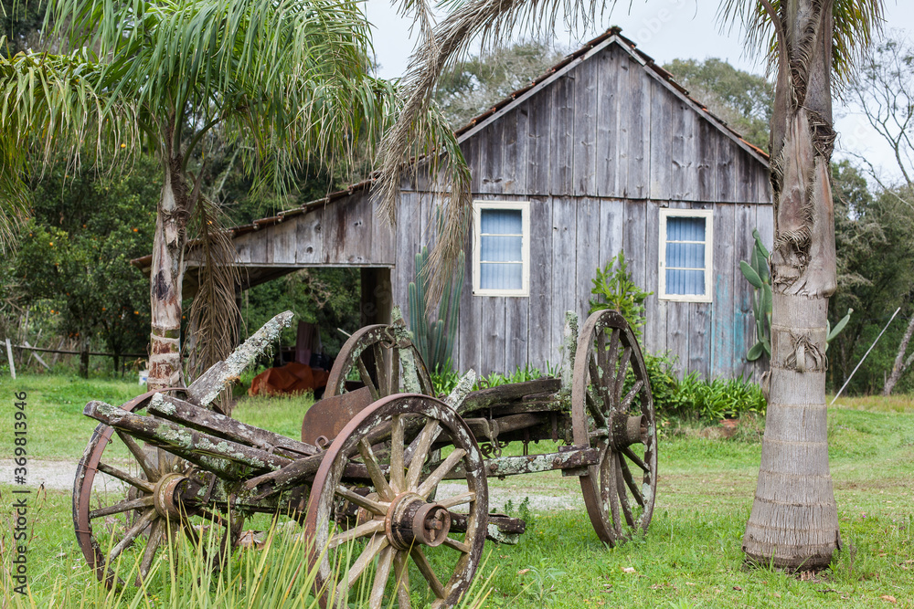 An old abandoned wagon with wooden houses in the background