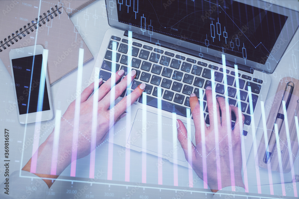 Double exposure of woman hands working on computer and forex graph hologram drawing. Top View. Financial analysis concept. Double exposure of woman hands working on computer and forex graph hologram drawing. Top View. Financial analysis concept.