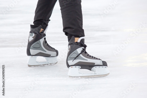 legs of a skating man on an ice rink. hobbies and leisure. winter sports