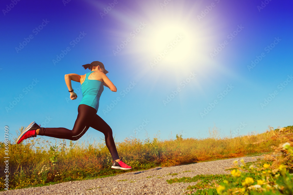 young white fitness woman runs up the countryside road. young white fitness woman runs up the countryside road.