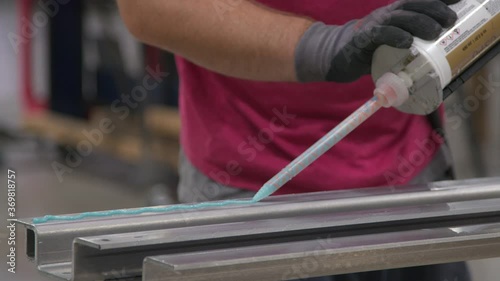 Wallpaper Mural Worker applies industrial adhesive to steel at factory with giant caulking gun Torontodigital.ca