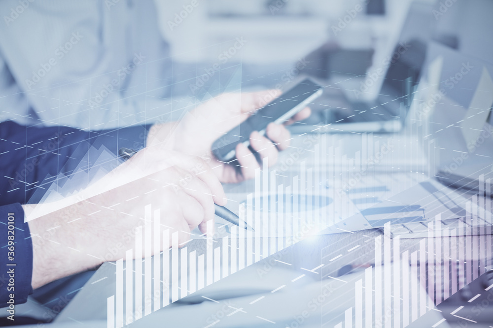 Double exposure of man's hands holding and using a digital device and forex graph drawing. Financial market concept. Double exposure of man's hands holding and using a digital device and forex graph drawing. Financial market concept.