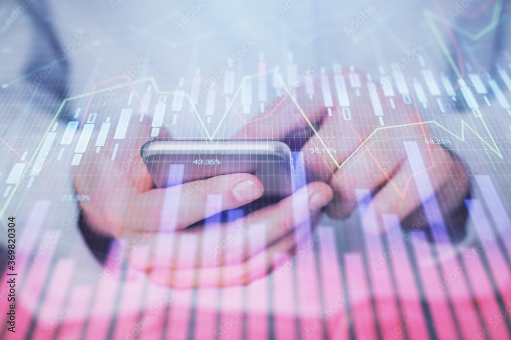 Double exposure of man's hands holding and using a digital device and forex graph drawing. Financial market concept. Double exposure of man's hands holding and using a digital device and forex graph drawing. Financial market concept.