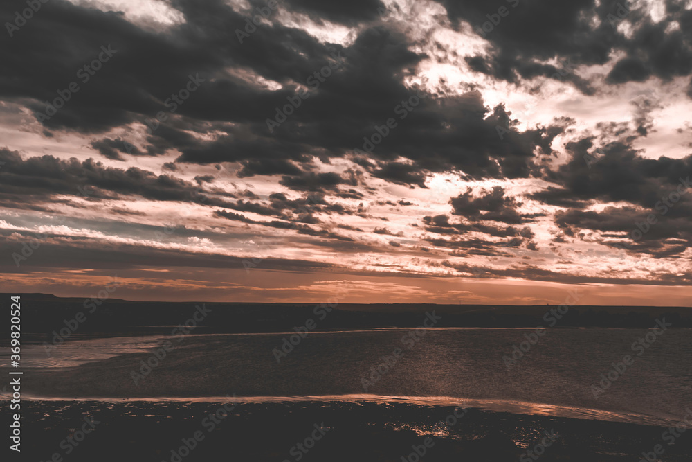 Fototapeta premium Dramatic sky over the coast at sunset