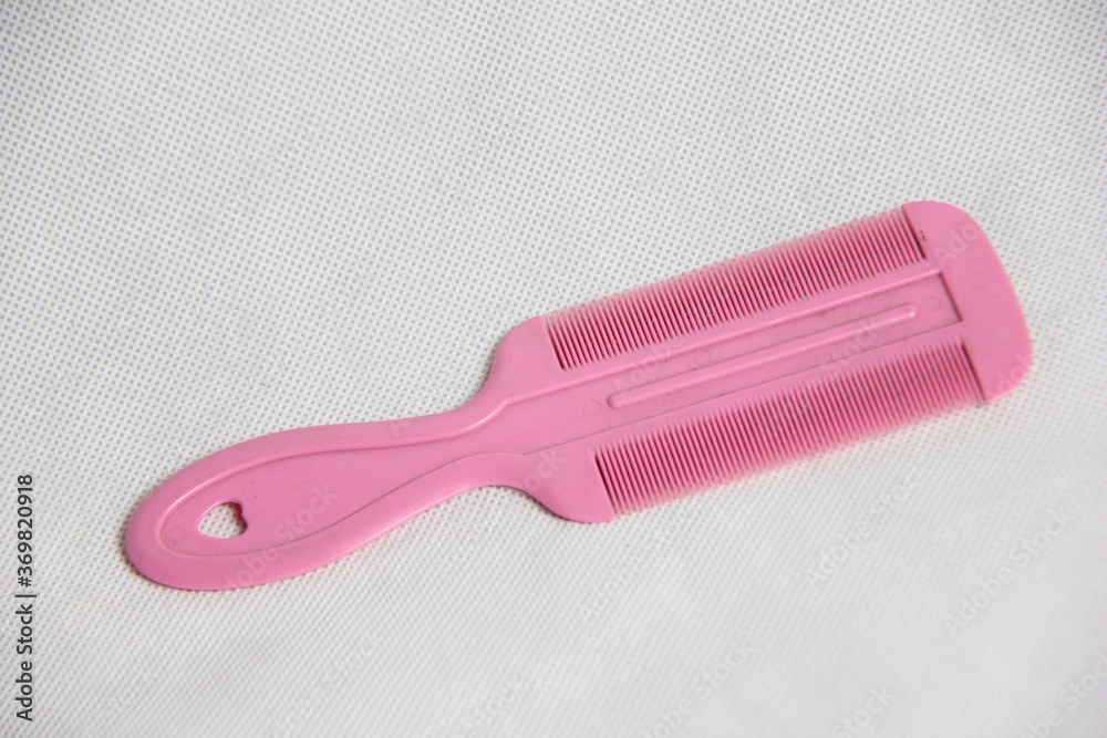 photograph of a pink plastic hair comb