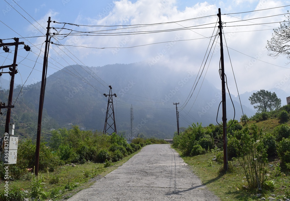 High voltage transmission lines with a beautiful hill view  in rural India