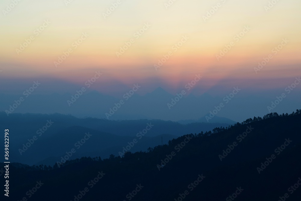 Kausani, Uttarakhand, India, Sunrise with crown-shaped light rays amidst the Himalayan mountains