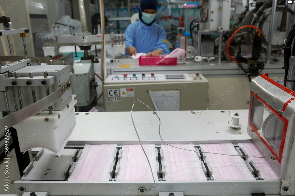 Factory workers are producing masks for protection against viruses.
