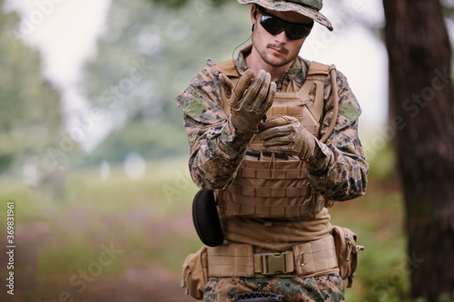 soldier preparing tactical and commpunication gear for action battle photo