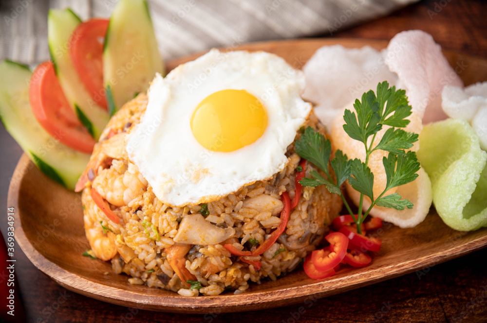 nasi goreng, indonesian fried rice on wooden plate nasi goreng, indonesian fried rice on wooden plate