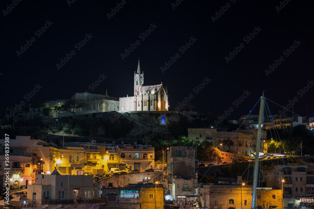 Ghajnsielem Parish Church illuminated from the bay by Gozo
