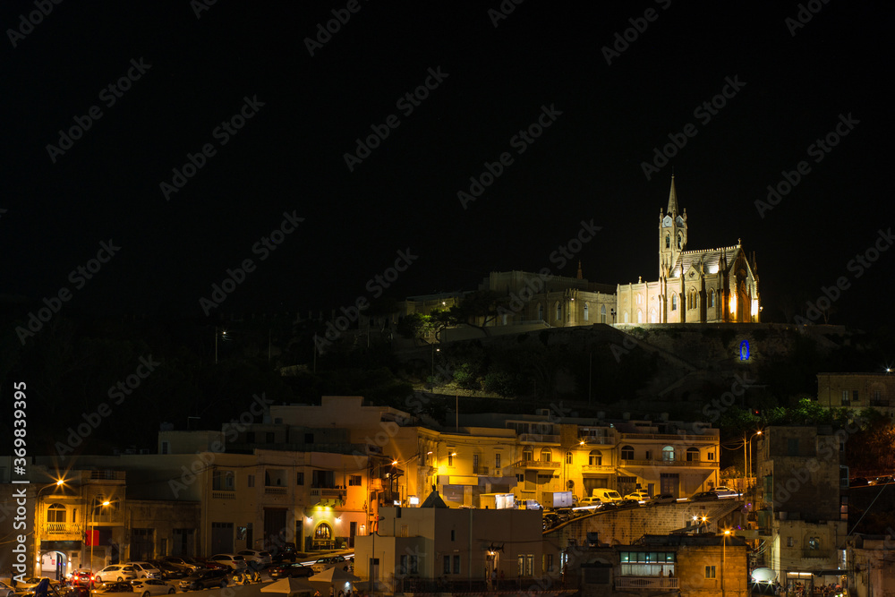 Ghajnsielem Parish Church illuminated from the bay by Gozo
