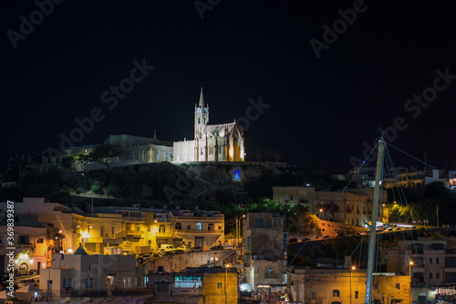 Ghajnsielem Parish Church illuminated from the bay by Gozo  © Lea Digszammal