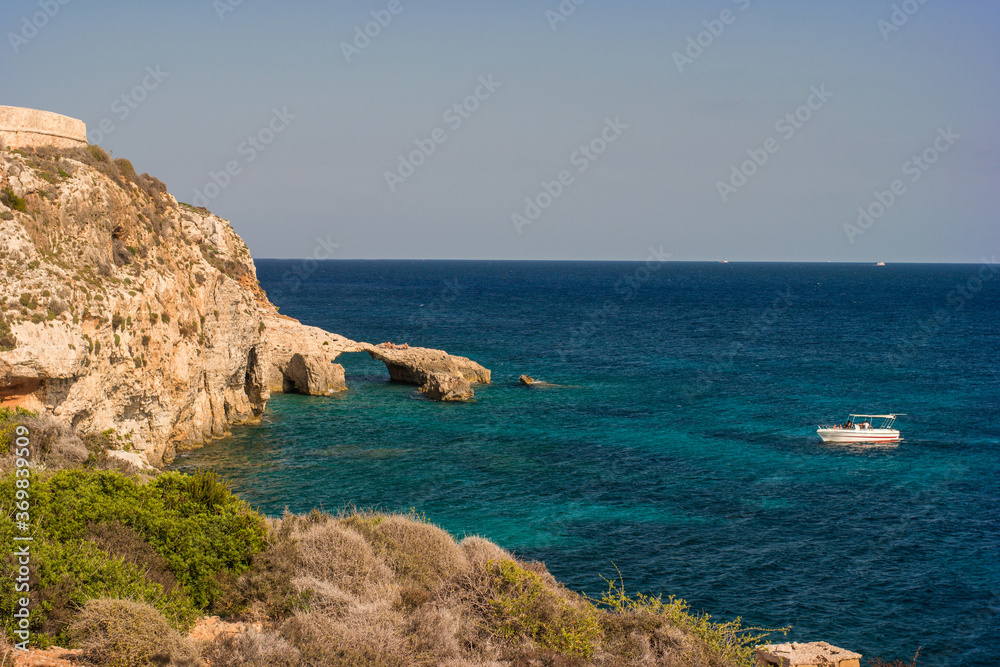 Rock arch and a boat in Comino island