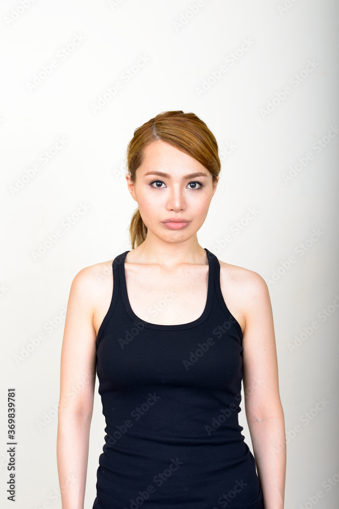Portrait of young beautiful Asian woman against white background Portrait of young beautiful Asian woman against white background