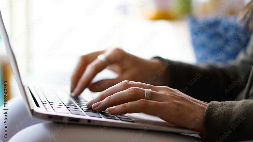 Young Woman's hands typing on a keyboard notebook