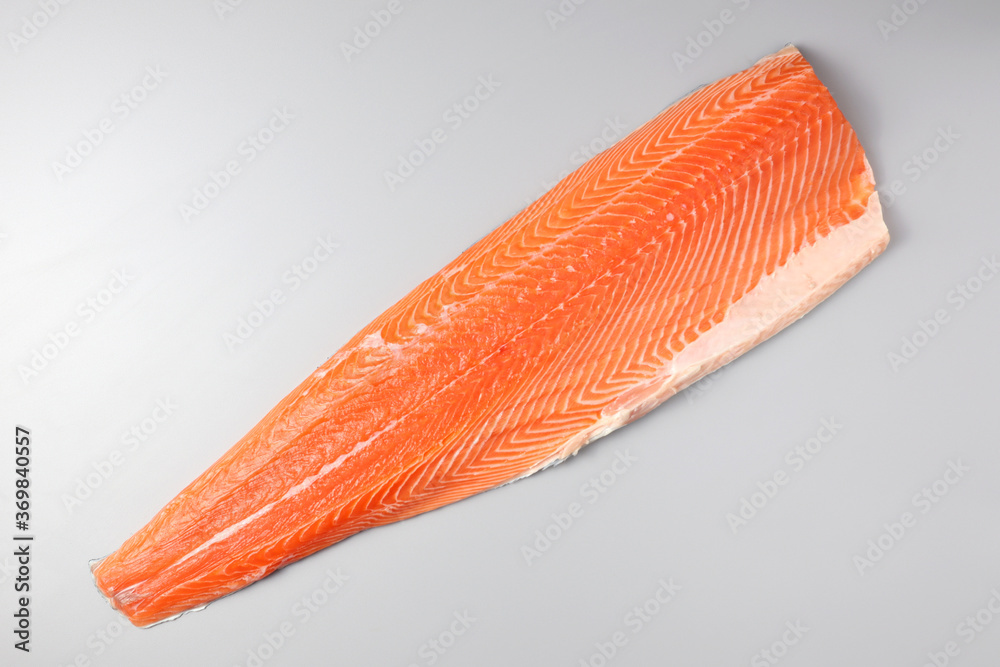 Fresh raw salmon fish steak with spices on ice over dark stone background. Creative layout made of fish, top view, flat lay Fresh raw salmon fish steak with spices on ice over dark stone background. Creative layout made of fish, top view, flat lay