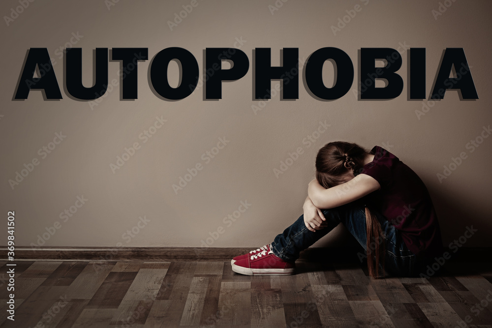Upset little girl sitting alone near beige wall. Autophobia - fear of ...