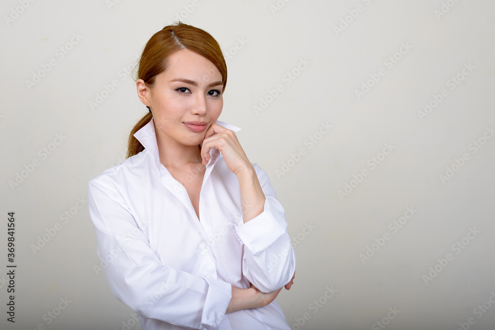 Portrait of young beautiful Asian businesswoman against white background Portrait of young beautiful Asian businesswoman against white background
