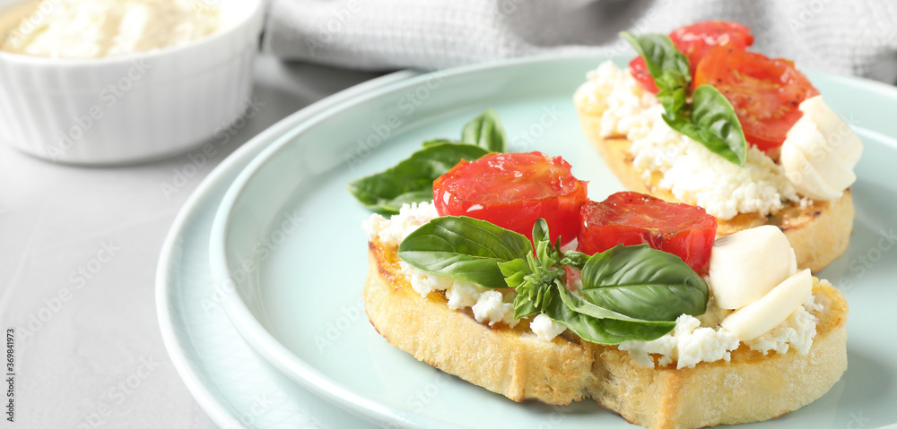 Tasty bruschettas with tomato on grey table, closeup. Banner design Tasty bruschettas with tomato on grey table, closeup. Banner design