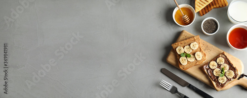 Tasty bruschettas with banana and chia seeds served on table, top view. Space for text, banner design
