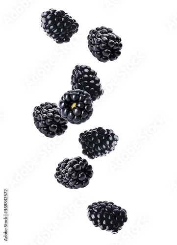 Fresh tasty blackberries falling on white background