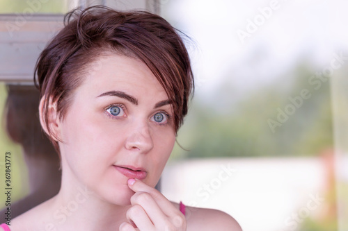 Portrait of a girl, thoughtfully touching her hand to her lips