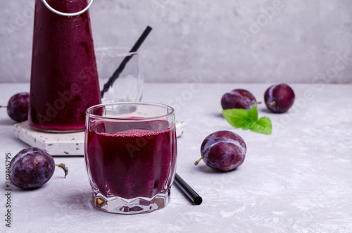 Red plum juice in glass photo