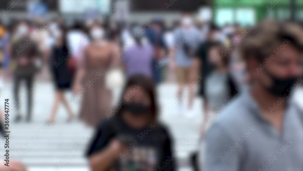 SHIBUYA, TOKYO, JAPAN - AUG 2020 : Crowd of people wearing surgical mask to protect from Coronavirus (COVID-19) at Shibuya Crossing. Shot in day time, hot summer season. Blurred slow motion. SHIBUYA, TOKYO, JAPAN - AUG 2020 : Crowd of people wearing surgical mask to protect from Coronavirus (COVID-19) at Shibuya Crossing. Shot in day time, hot summer season. Blurred slow motion.