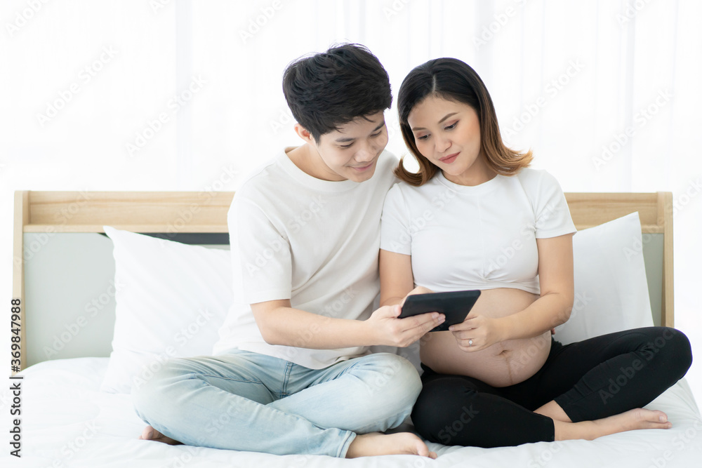 Romantic husband and wife using tablet on the bed in bedroom. Romantic husband and wife using tablet on the bed in bedroom.