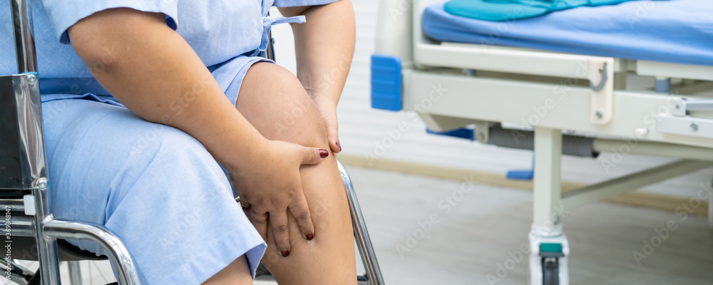 Asian fat woman touching on her knee, woman patient hurt on her knee close up.