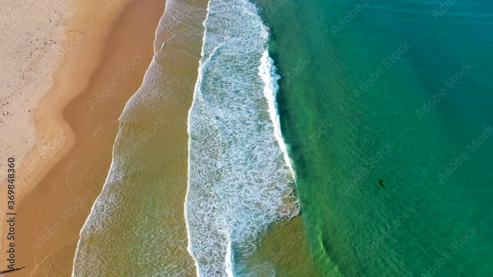 Tilting up drone shot from surf to island at Redhead Beach Australia Tilting up drone shot from surf to island at Redhead Beach Australia