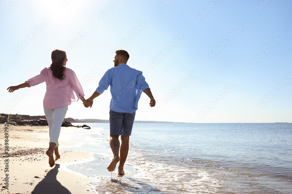 Happy young couple on beach near sea. Honeymoon trip Happy young couple on beach near sea. Honeymoon trip