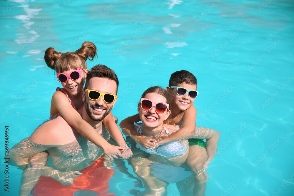 Happy family in swimming pool on sunny day Happy family in swimming pool on sunny day
