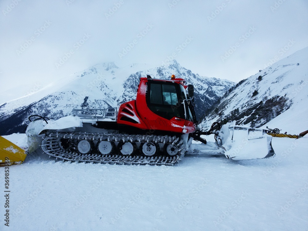 Beautiful modern tracked snowplow tractor in the mountains Beautiful modern tracked snowplow tractor in the mountains