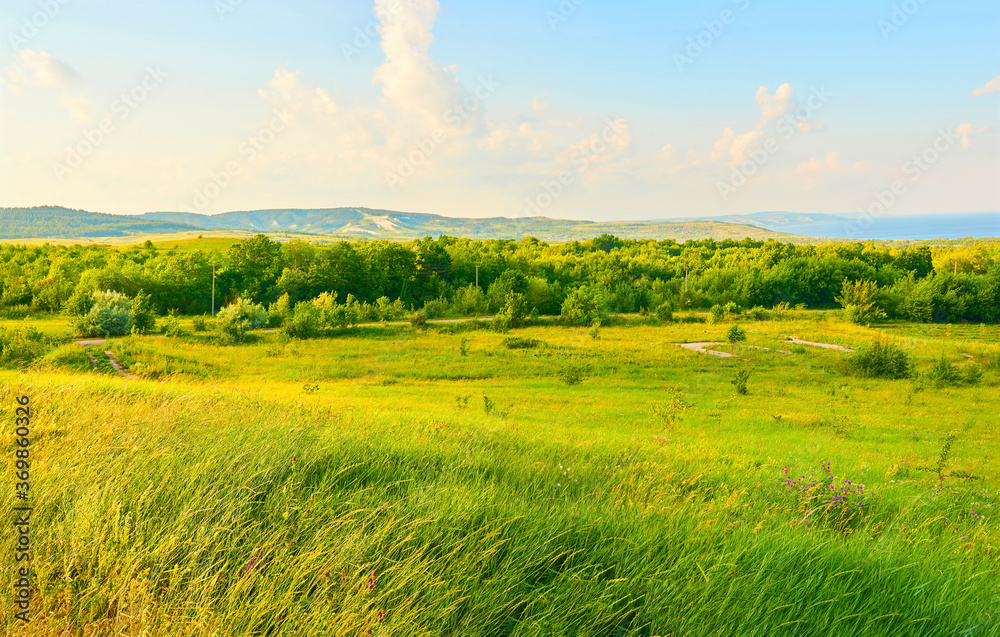 Fototapeta premium Beautiful fields against the backdrop of mountains and blue sky with clouds.