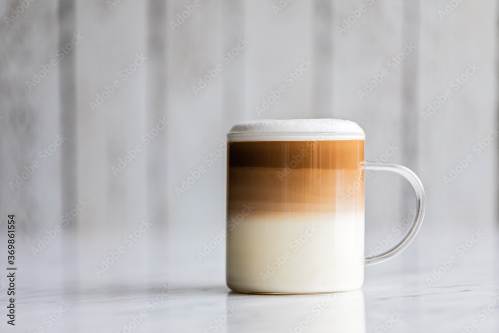 Cafe latte macchiato layered coffee in a see through glass cup on white background. - obrazy, fototapety, plakaty 