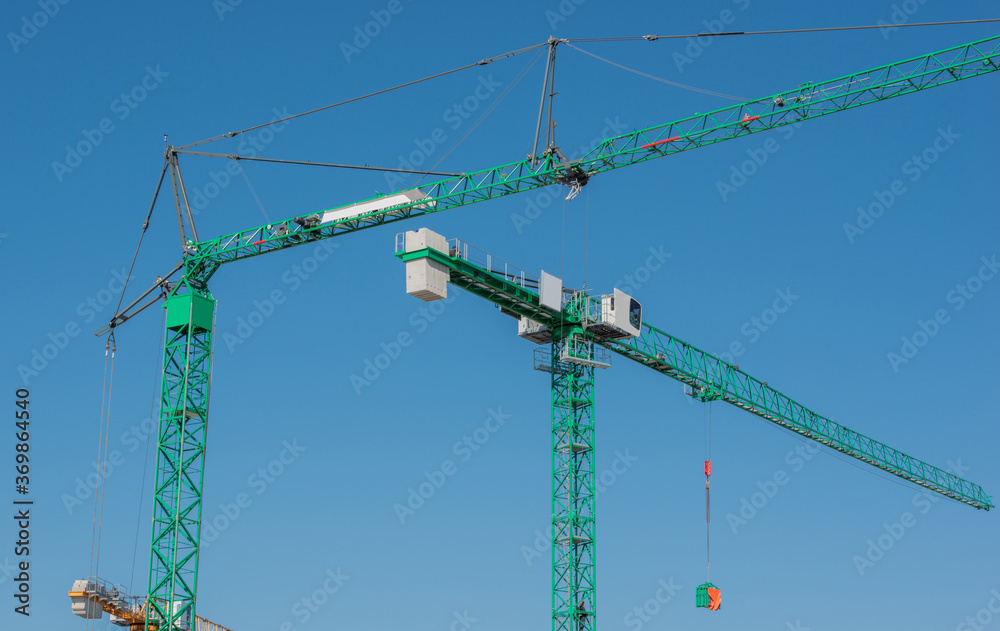 Mobilbau- und Turmdrehbaukran bei einer Baustelle für Gebäudebau Mobilbau- und Turmdrehbaukran bei einer Baustelle für Gebäudebau