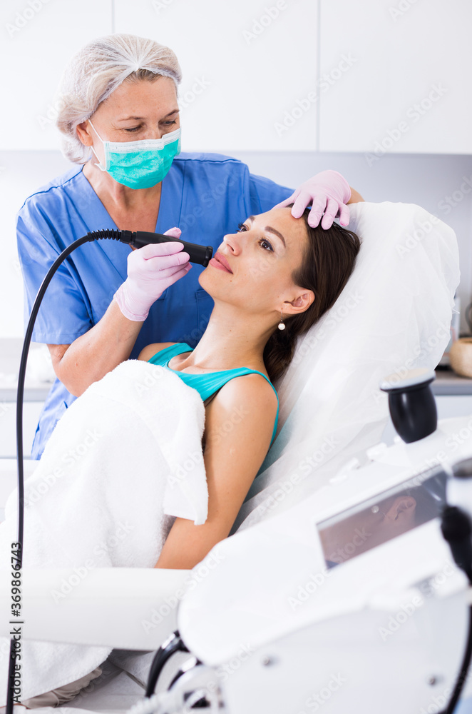 Fototapeta premium Woman receiving innovative procedure of cryoliposuction in clinic of esthetic cosmetology