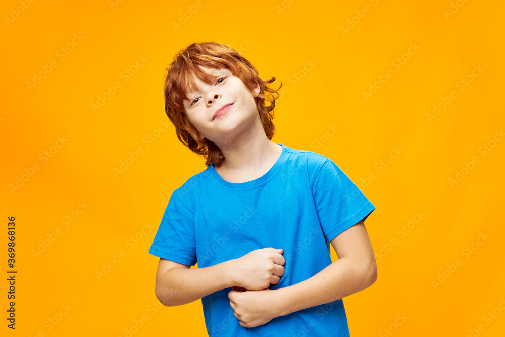 The red-haired child smiles and touches his stomach The red-haired child smiles and touches his stomach