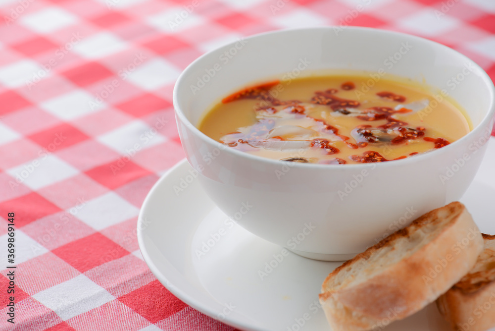 Hot and sour soup with shrimps and clams. Sea food soup with sauce served in a white bowl over light rustic wooden table Hot and sour soup with shrimps and clams. Sea food soup with sauce served in a white bowl over light rustic wooden table