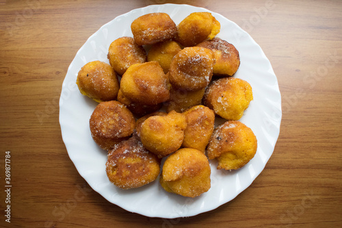 Chulas de Calabaza o buñuelos de calabaza en un plato blanco sobre fondo de madera. Postre típico de carnaval en Galicia (España).