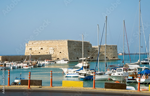 Greece Heraklion port with boats, street lamppost and old tower photo