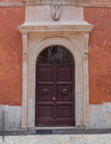 vintage house entrance natural wood door and white arched frame, Rome Italy © Dimitrios