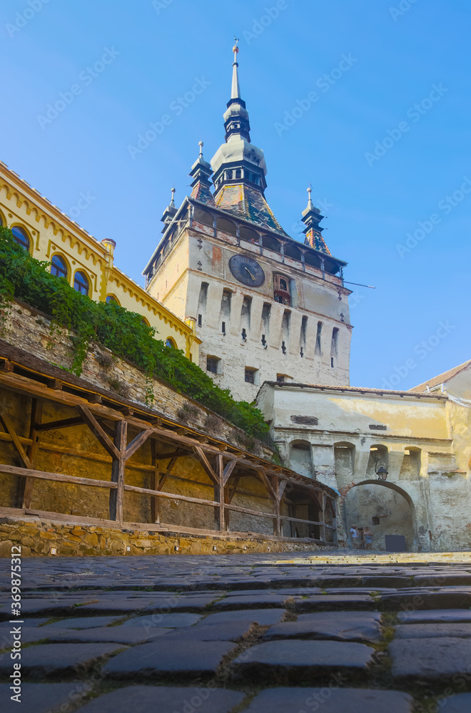 Obraz premium View of medieval clock tower from fortress square, famous tourist attraction in romanian town Sighisoara.