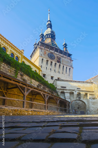 View of medieval clock tower from fortress square, famous tourist attraction in romanian town Sighisoara. photo