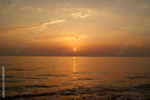 Beautiful dawn over the sea. Sunny path on the water. Light wave and swell on the surface of the water